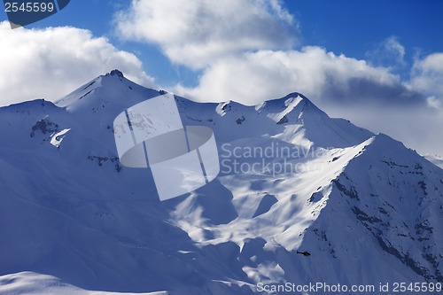 Image of Off piste slope for heliskiing and helicopter in evening