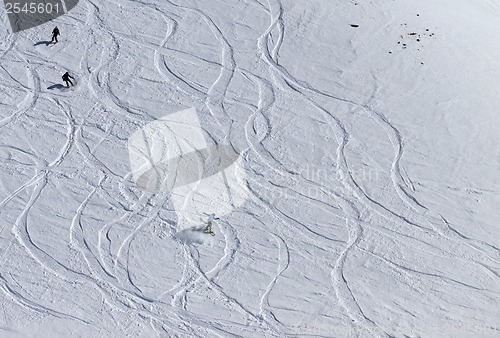 Image of Snowboarders and skiers downhill on off piste slope.