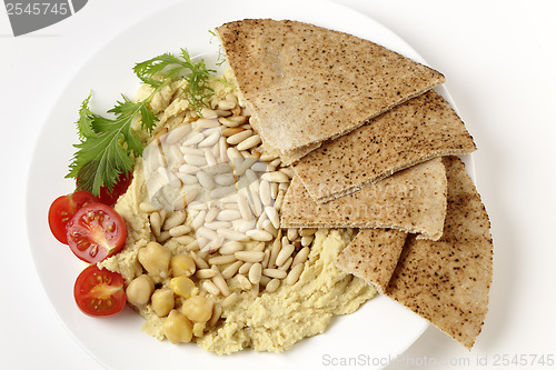 Image of Lebanese hummus and pine nuts from above