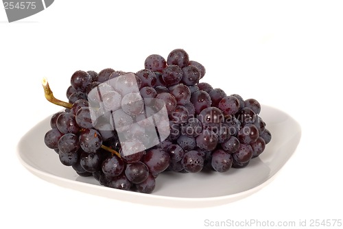 Image of A bunch of juicy red grapes on a white plate