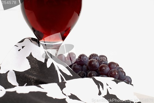 Image of Low view of a wine glass with wine and grapes and napkin