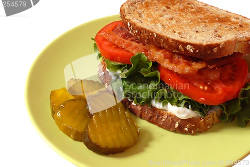 Image of Closeup of a bacon, lettuce and tomato sandwich with pickles