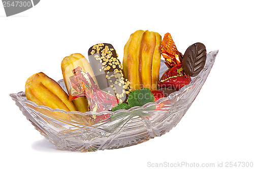 Image of Cakes and sweets in a crystal vase on a white background