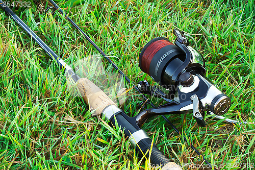 Image of Spinning fishing on the green grass by the river.