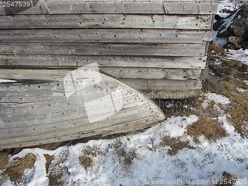 Image of Old wooden boat by an wooden house