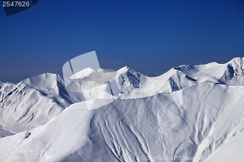 Image of Off-piste slope with traces of skis and snowboards in nice day