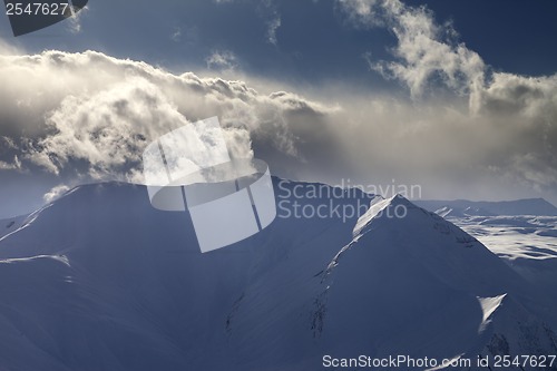 Image of Mountains in evening with sunlit clouds