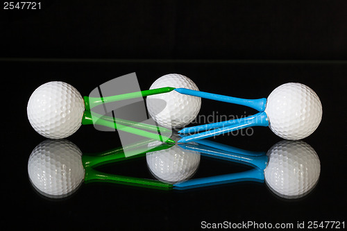 Image of White golf balls and different colored tees