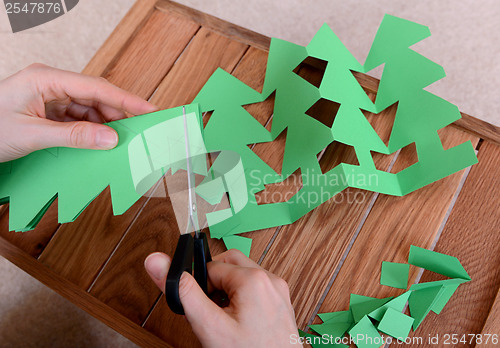 Image of Cutting green card into a chain of Christmas trees