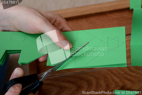 Image of Closeup of cutting a Christmas tree paper chain
