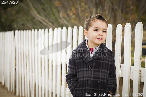 Image of Young Mixed Race Boy Waiting For School Bus Along Fence Outside.