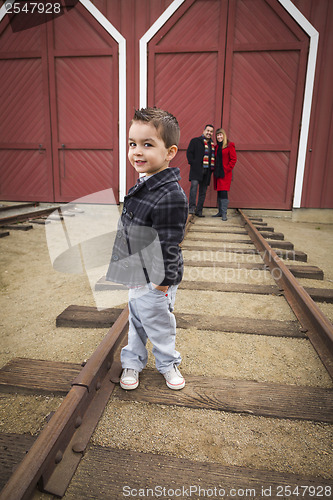 Image of Mixed Race Boy at Train Depot with Parents Smiling Behind