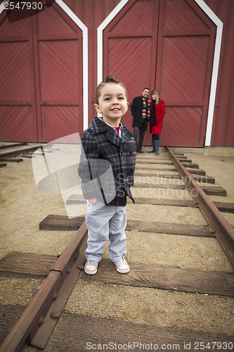 Image of Mixed Race Boy at Train Depot with Parents Smiling Behind