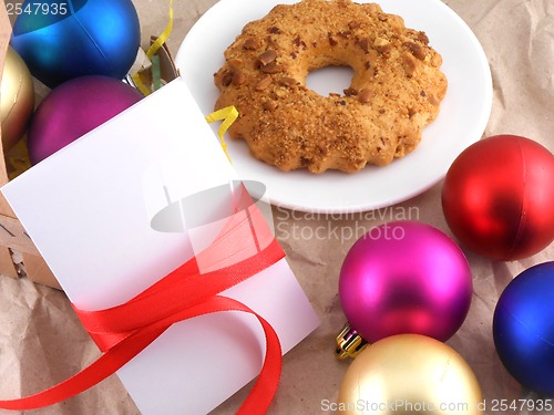 Image of cake with christmas balls and white invitation card