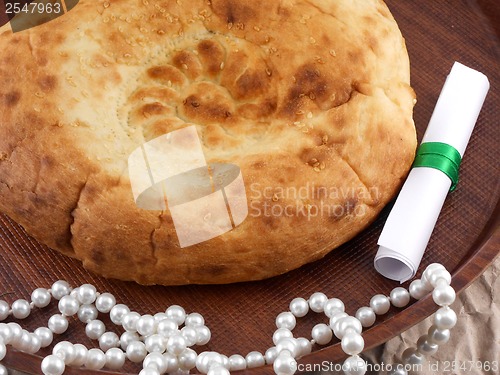 Image of Home bakery, bread on wooden plate with pearls and invitation card