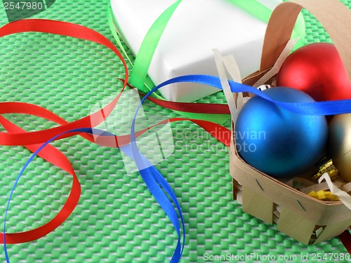 Image of Christmas balls and white gift box on green background