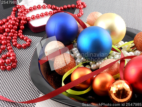 Image of decorative christmas ball and pearls on a plate, new year holiday