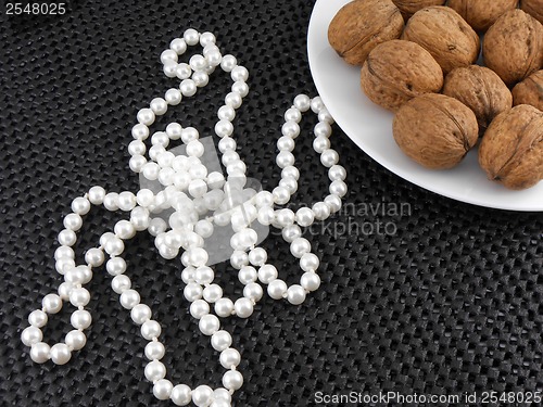 Image of Walnuts on a white plate with white pearls