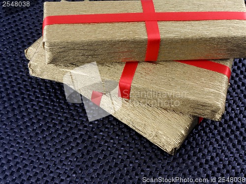 Image of golden gift box with red ribbon, holiday concept