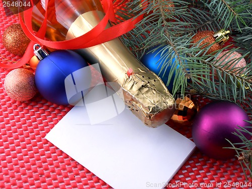 Image of champagne bottle with christmas ball and red ribbon, invitation card