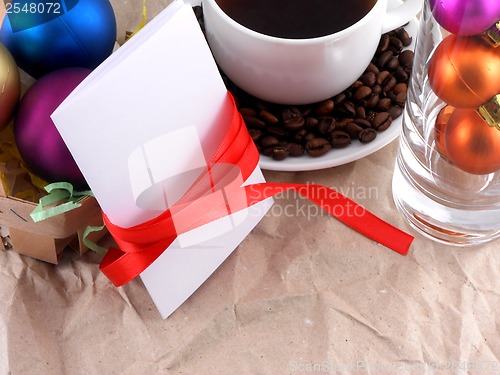 Image of cup of coffee with coffee beans, christmas balls and invitation card