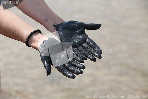Image of hands in black mud