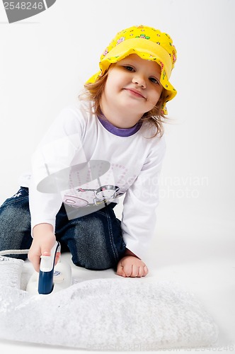 Image of little, blond hair girl in hat ironing