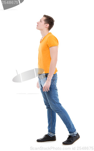 Image of Young man wearing a yellow T-shirt and slim jeans