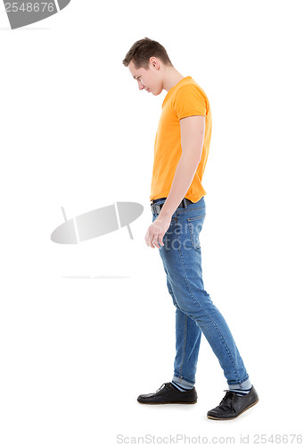 Image of Young man wearing a yellow T-shirt and slim jeans