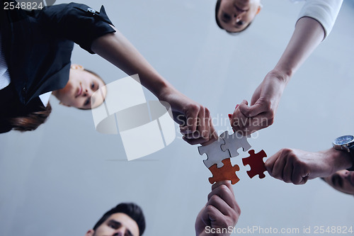 Image of Group of business people assembling jigsaw puzzle