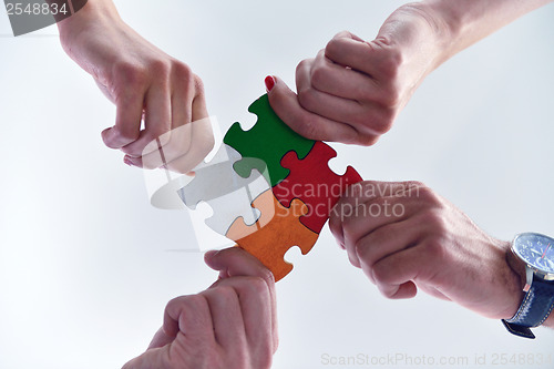 Image of Group of business people assembling jigsaw puzzle