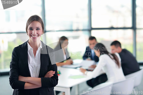 Image of business woman with her staff in background at office