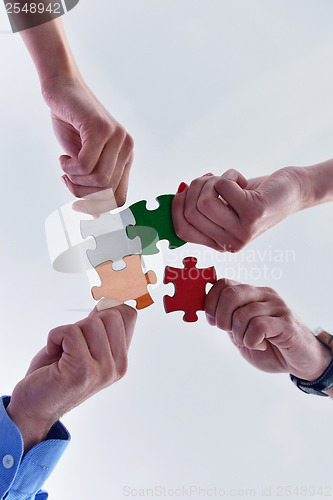 Image of Group of business people assembling jigsaw puzzle