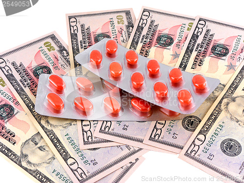Image of medical pills on dollars bank note as symbol for high costs
