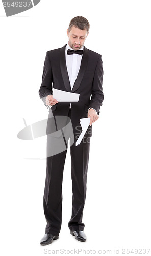 Image of Man in a tuxedo reading the document