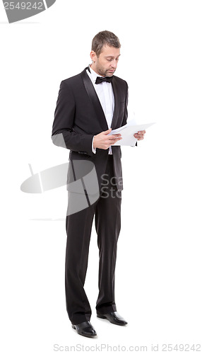 Image of Man in a tuxedo reading the document