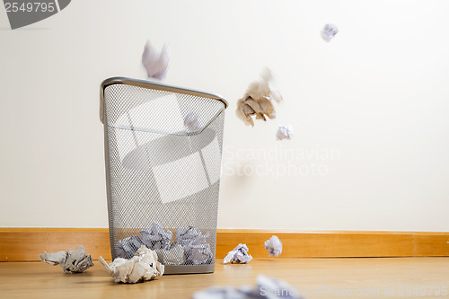 Image of Silver trash bin and crumpled papers