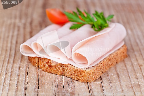 Image of bread with sliced ham, fresh tomatoes and parsley