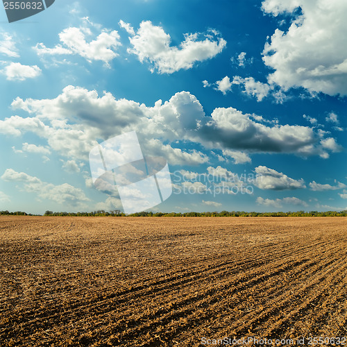 Image of plowed field and cloudy sky in sunset