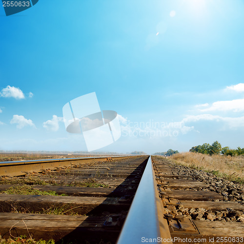 Image of hot sun in blue sky over old railroad