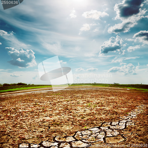 Image of desert earth wirh cracks under dramatic sky