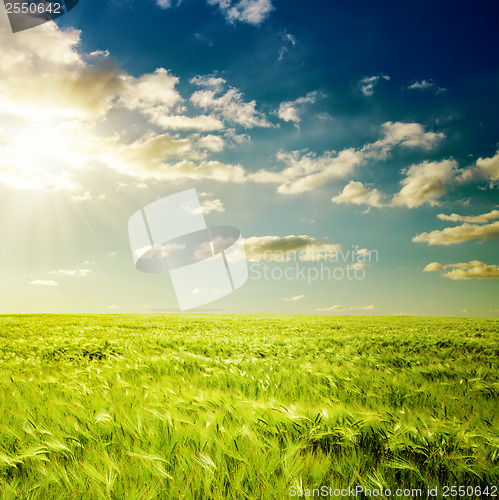 Image of dramatic sunset and green field