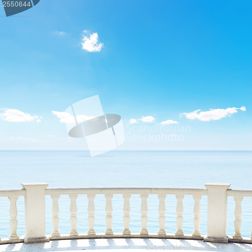 Image of white balcony on terrace near sea and blue sky