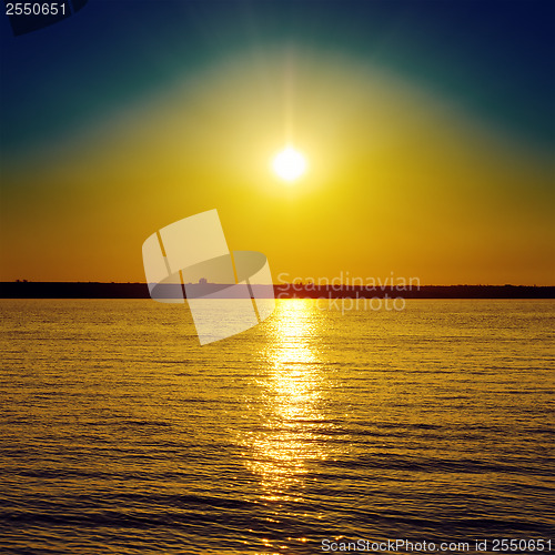 Image of orange sunset over dark water