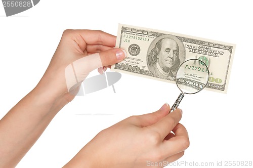 Image of Hand with magnifying glass and dollars