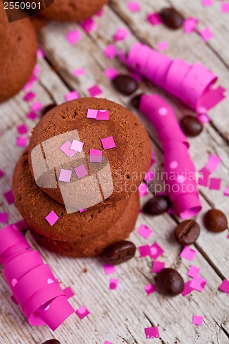 Image of fresh chocolate cookies, coffee beans, pink ribbons and confetti