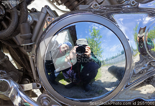 Image of Two motorcyclists are reflected in brilliant motor