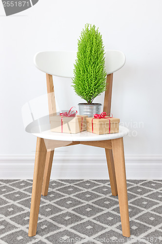 Image of Presents and little green tree on a white chair