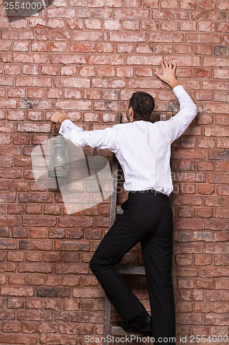 Image of Man up against a brick wall