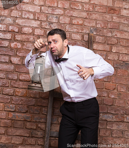 Image of Scared man searching with an oil lamp